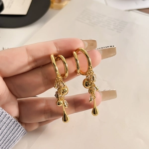 Detail of 18K gold plated C-ring fringe earrings with dangling metal balls and crystals
