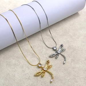 Detail shot of dragonfly pendants with hollow wings and inlaid zircon on metal chains