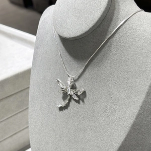 Exquisite silver dragonfly necklace with sparkling cubic zirconia on a gray velvet neck bust