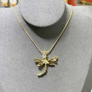 Detailed view of dragonfly pendant necklace with clear zircon stones on grey neck model