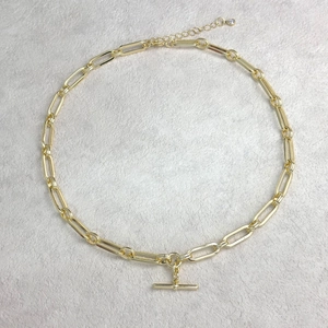 Detail of 14K gold plated paperclip chain necklace with a toggle clasp and zircon drop