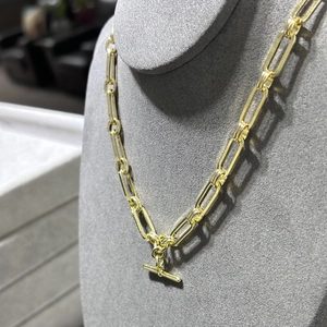 Detail of 14K gold plated brass paperclip chain necklace with toggle clasp on display