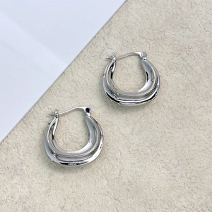 Pair of thick silver U-shaped hoop earrings with minimalist irregular textured design