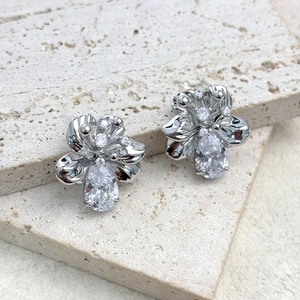 Detailed macro view of silver flower stud earrings featuring sparkling pear-cut zircon stones