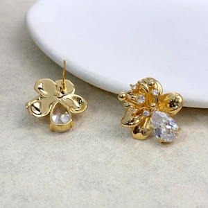 Macro shot of gold flower stud earrings with teardrop zircon and pavé crystal details
