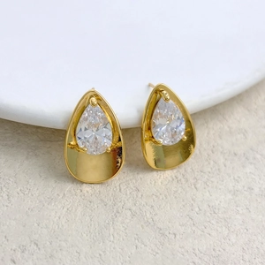 Macro detail of tear-drop zircon earrings with gold plating and prong setting