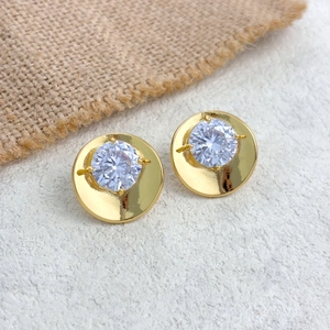 Macro detail of gold plated disc earrings with brilliant-cut round cubic zirconia stones