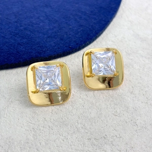 Detailed view of square clear zircon stud earrings with gold plating on a textured base