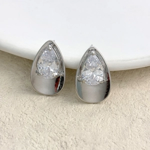 Macro view of pear-cut zircon stud earrings in high-polished claw setting frames