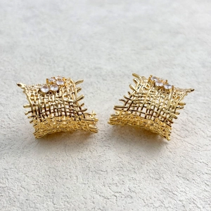 Detail of gold woven earrings featuring hollow mesh texture and sparkling cubic zirconia