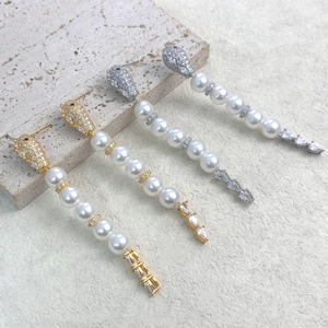 Detailed macro view of panther head earrings with zircon paving and long pearl tassels
