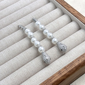 Detail of silver snake head drop earring with white pearls and micro-pave zircons