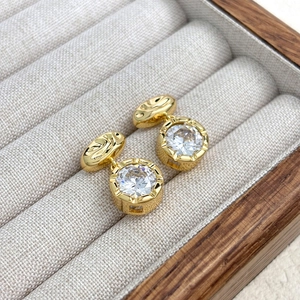 Detailed close-up of 18K gold plated earrings with large round-cut sparkling zircons