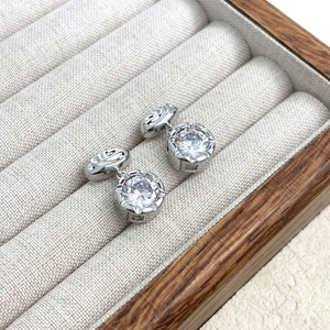 Detail of silver silver cufflinks with large round zircon in a 6-claw setting and wood box