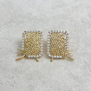 Detail of gold woven rectangle earrings with pavé crystal borders and metal accents