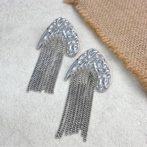 Détail de boucles d'oreilles croissant argenté martelé avec de longues franges
