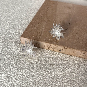 Elegant silver snowflake firework stud earrings with textured metallic finish
