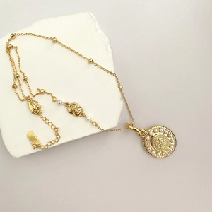 Collier médaillon solaire doré avec bordure de perles blanches et pendentif géométrique