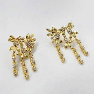 Fashionable gold-plated leaf tassel earrings with sparkling zircon stones on white background