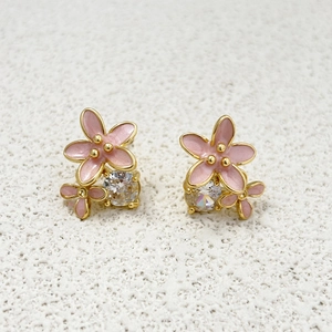Detail of pink enamel flower earrings with sparkling zircons on 18k gold plated base