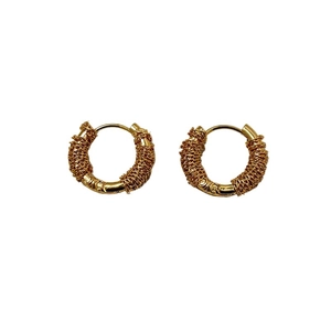 Macro detail of French style 18K gold plated hoop earrings with wire-wrapped texture