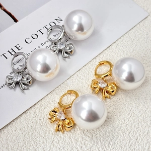 Boucles d'oreilles nœud or et argent avec zircon cœur et grandes perles en vue inclinée