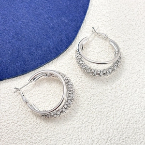 Gros plan de boucles d'oreilles double créoles argentées avec pavé de zircons