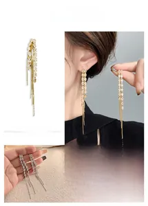 Detail of long fringe tassel earrings with wheat leaf design and sparkling rhinestones