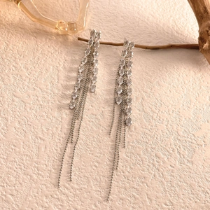 Macro detail of leaf tassels earrings with sparkling marquise stones on branch