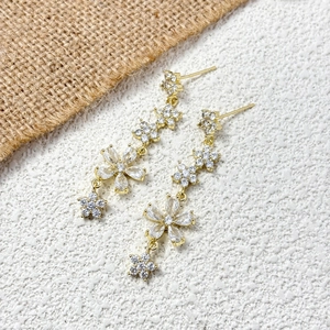 Orecchini pendenti a fiore dorati con cristalli scintillanti e design a catena floreale