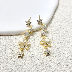 Dettaglio di orecchini a fiore dorati con cristalli scintillanti e design a catena elegante