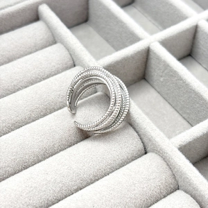 Close-up of silver multilayer ring with beaded edges in a jewelry storage case