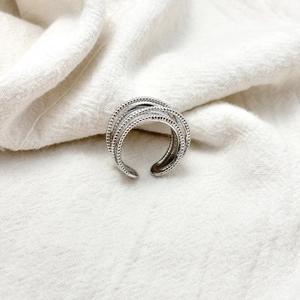 Detailed view of silver multi-layer beaded ring with textured finish on white linen
