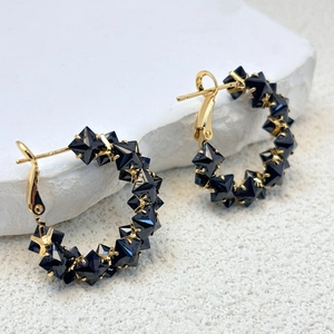 Macro shot of S925 hallmark on gold-plated hoop earrings with blue pyramid stones