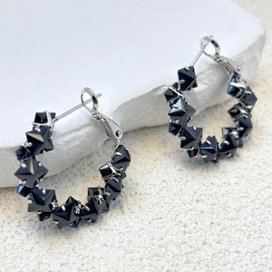 Detail of s925 silver hoop earrings featuring micro-set black pyramid zircon accents