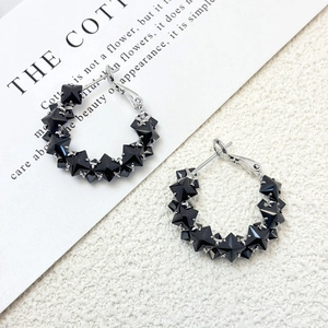 Detailed close-up of s925 silver hoop earrings featuring black star geometric elements