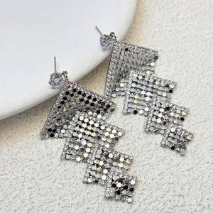 Macro view of silver geometric tiered square tassel earrings with cubic zirconia