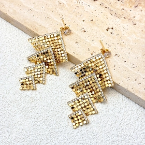 Detailed view of square gold fringe earrings with micro-pave zircons on stone base