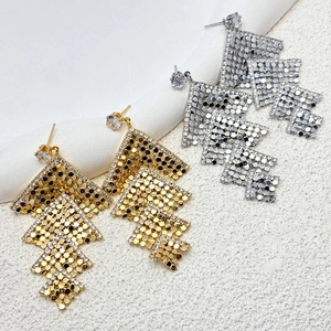 Detail view of gold and silver layered geometric mesh earrings with zircon accents