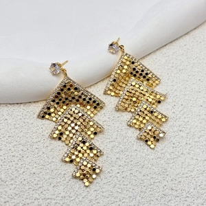 Close-up of golden cascading rhombus earrings with shimmering sequins and zircon stones