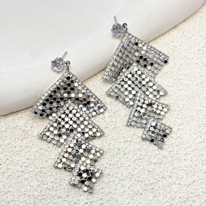 Macro shot of silver geometric mesh tassel earrings with sparkling zircon crystal stud