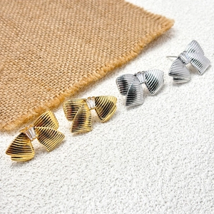 Boucles d'oreilles nœuds métalliques avec pierres de zircon en finitions or et argent