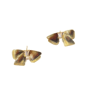 Boucles d'oreilles nœud dorées avec texture plissée et zircon sur fond blanc pur