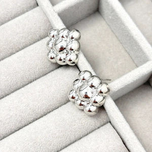 Macro view of polished S925 silver bubbly stud earrings with mirror finish texture