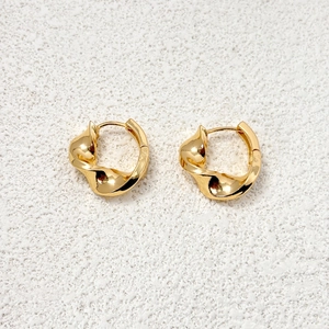 Detailed macro shot of 18K gold plated hoop earrings with spiral twisted texture design