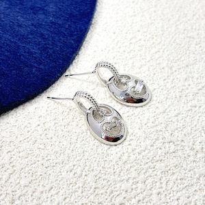 Detail of silver oval earring with heart cutout and baguette cut cubic zirconia stones