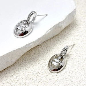 Macro shot of S925 silver oval earrings featuring rectangle zircon and beaded edges