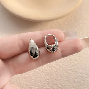 Detailed view of silver-toned waterdrop earrings with a polished metallic finish