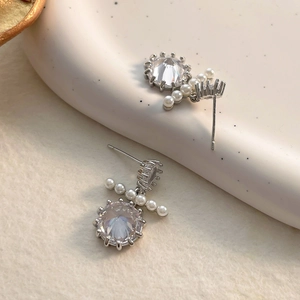 Detailed shot of moissanite studs featuring sparkling round stones and elegant white pearls