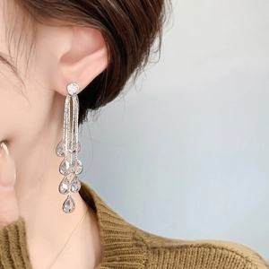 Elegant long tassel earrings with silver metal chains and teardrop stones on a model
